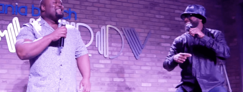 Two comedians performing on stage with microphones.